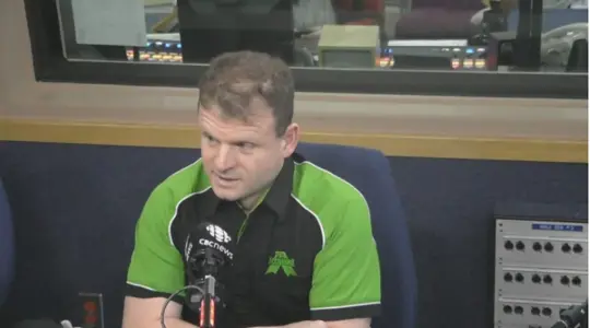 A man is being interviewed in a studio